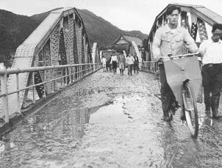 昭和28年の大水害にも耐えた綾部大橋。水が引いたあと、橋を行き交う市民ら＝市提供