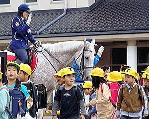騎馬隊に見守られ下校する児童ら