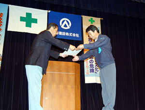 浅巻社長（左）から表彰状を受ける協力会社の代表