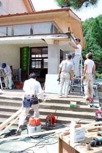 上林中の玄関の屋根を修理する組合員たち